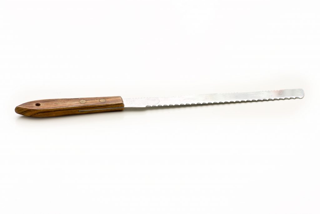 A bread knife with a wooden handle on a white background