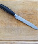 Serrated Utility Knife on a Wooden Cutting Board