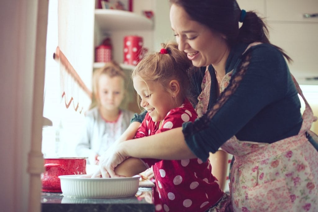 A woman and her child are kneading dough