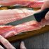 Filleting trout , removing rib bones with sharp fillet knife on wood