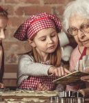Grandma and granddaughters spreading dough