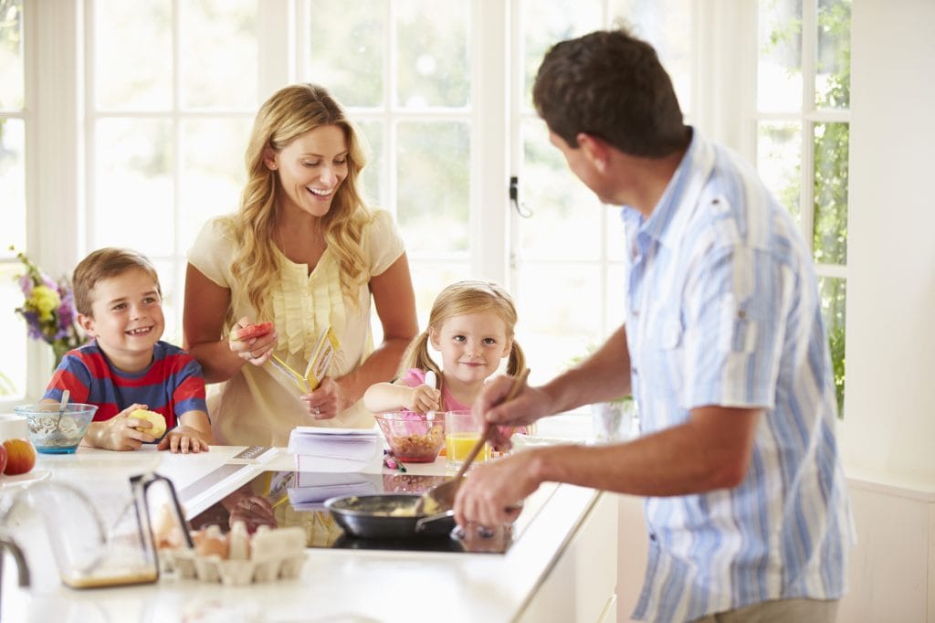 Father Preparing Family Breakfast In Kitchen