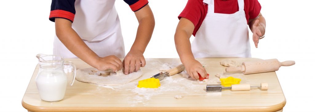 Children making cookies dressed as chefs