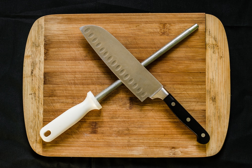 https://knivesacademy.com/wp-content/uploads/2022/07/A-knife-sharpener-or-honing-steel-and-a-chef-k.jpg