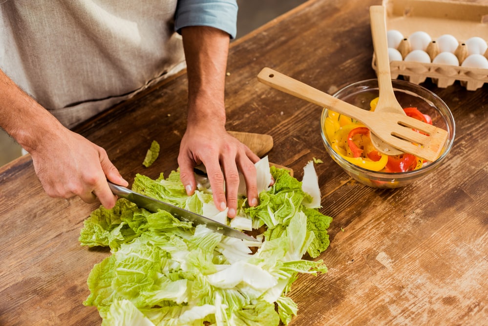 Cropped shot of man in apron chopping cabbage a