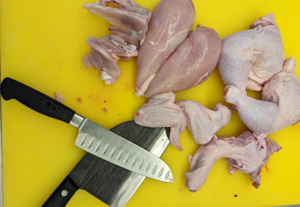 Cut Up a Whole Chicken on a yellow cutting board