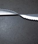 Serrated knives on a dark gray table — Photo