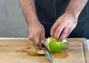 The Mercer, held by our tester, while peeling a orange on a cutting board