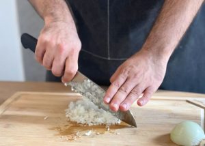 The Mercer, held by our tester, while chopping onion on a cutting board